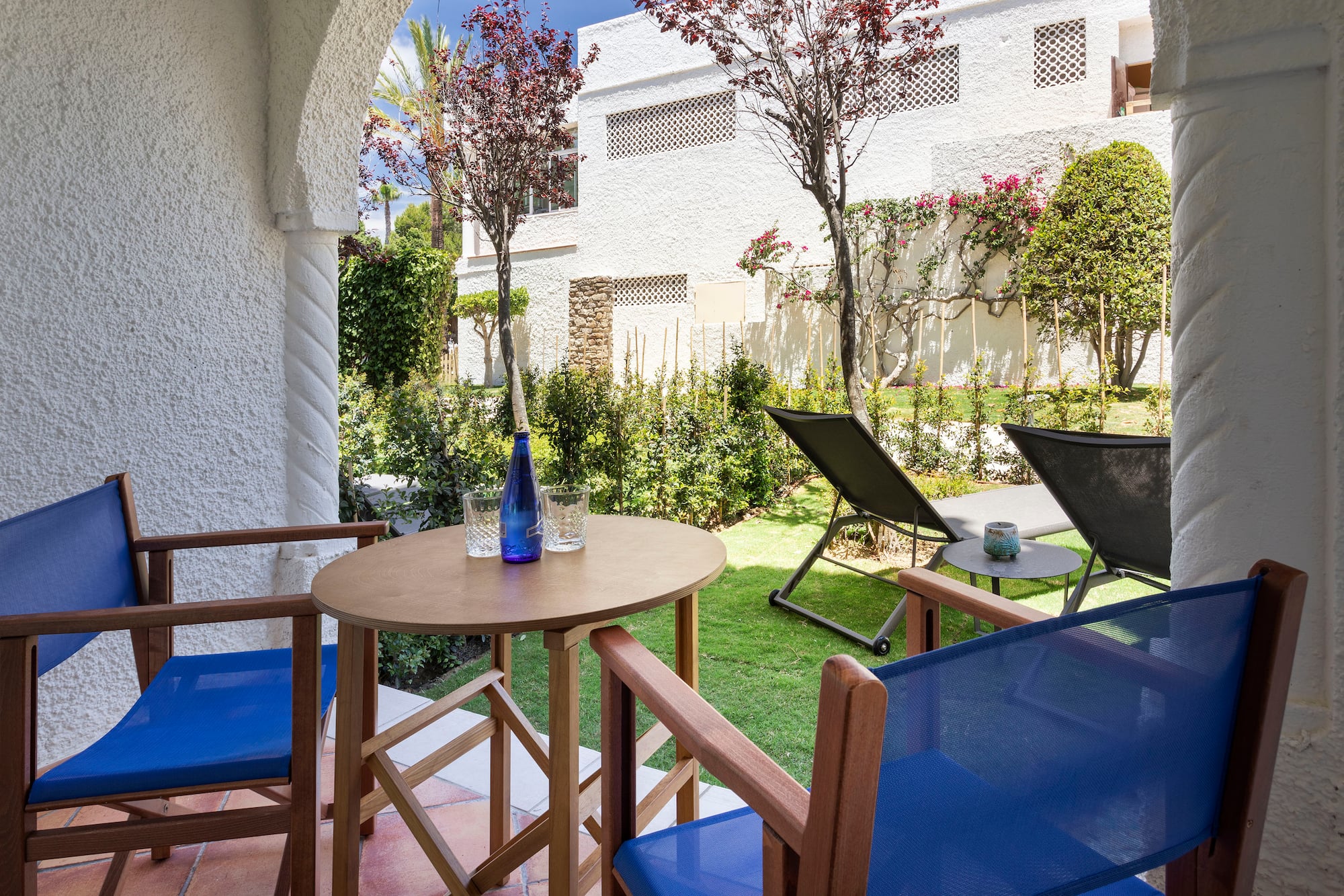 a table and chairs outside with a building in the background