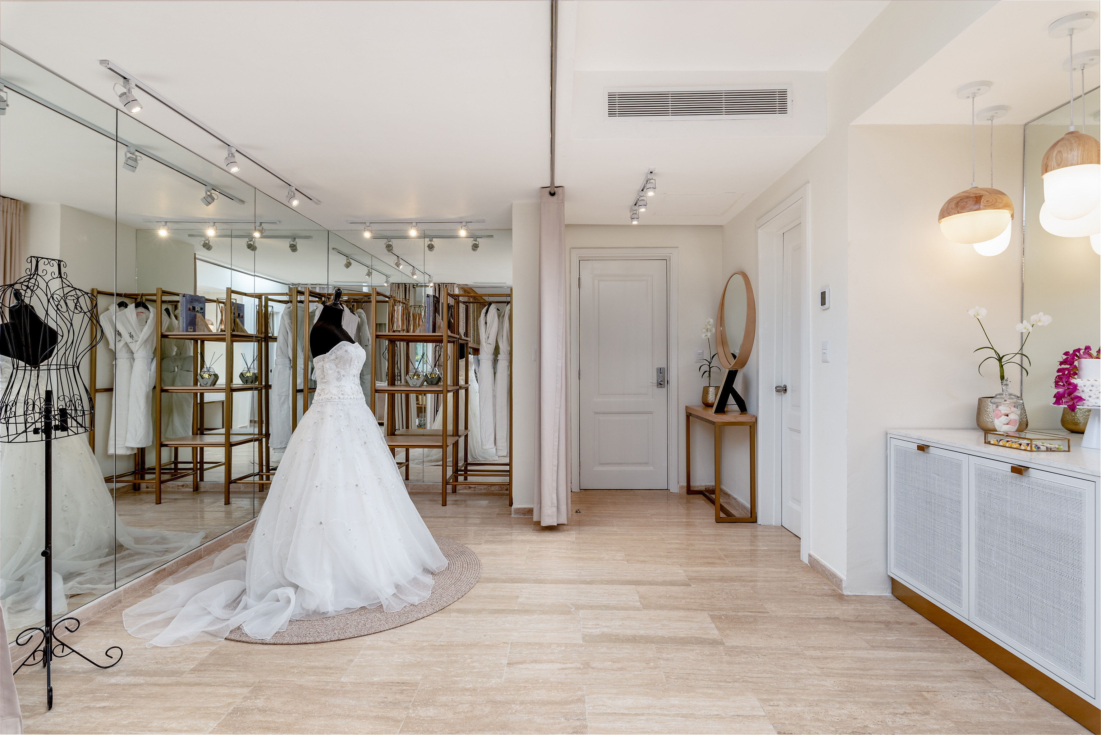 Elegant bridal boutique showroom with white wedding dress and mirrors.