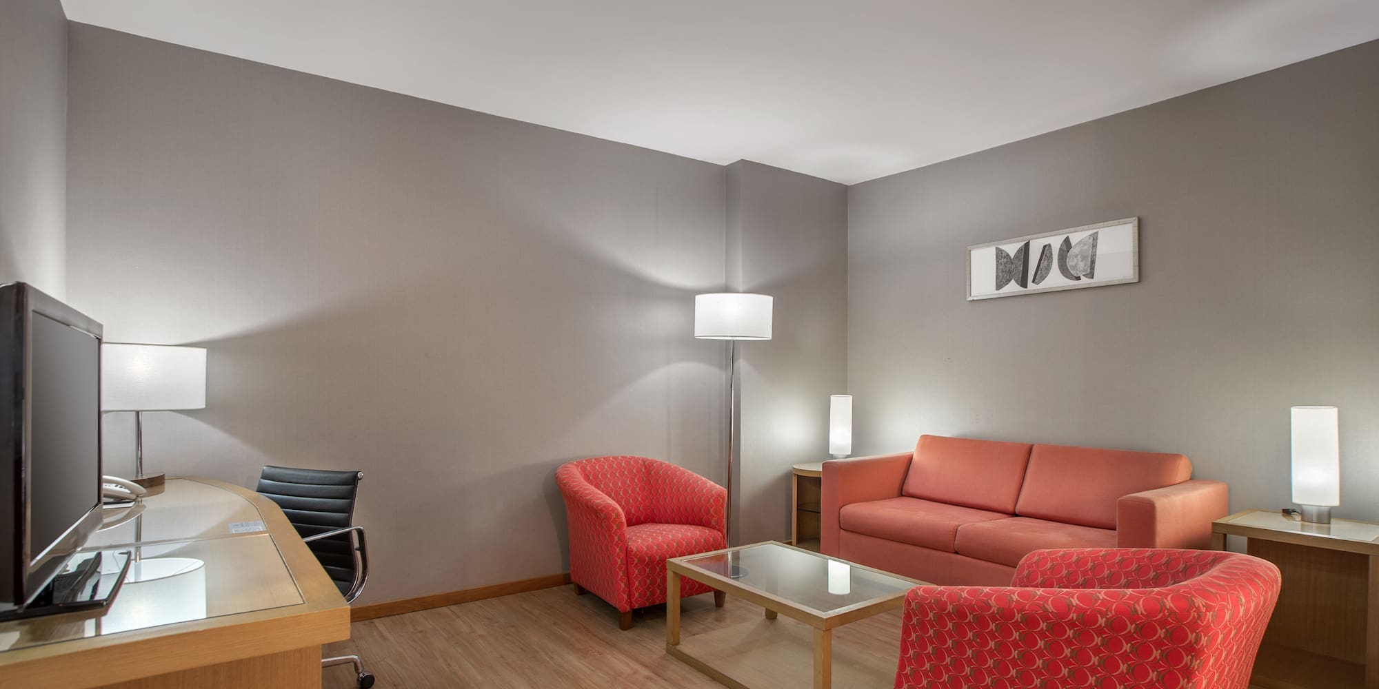 a room with a desk and couches