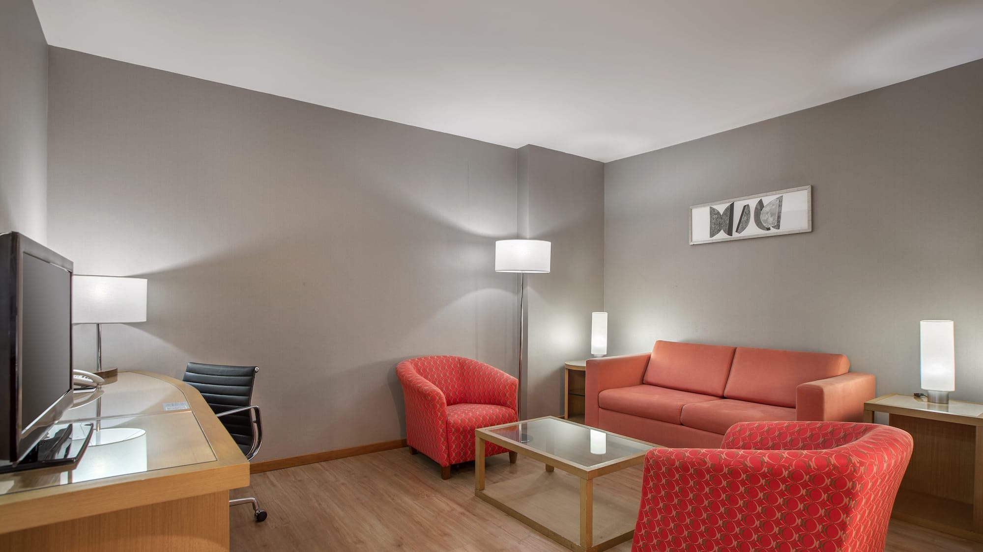 a room with a desk and couches