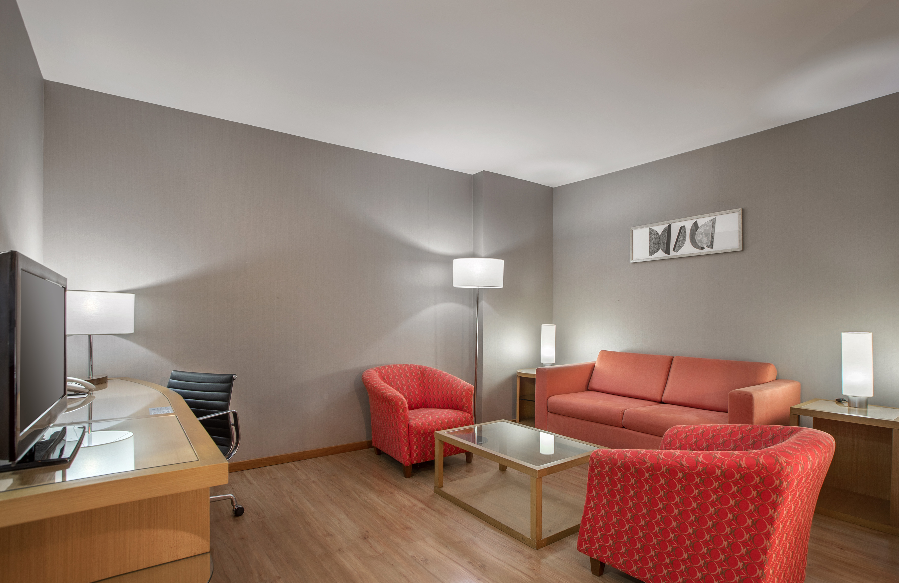 a room with a desk and couches