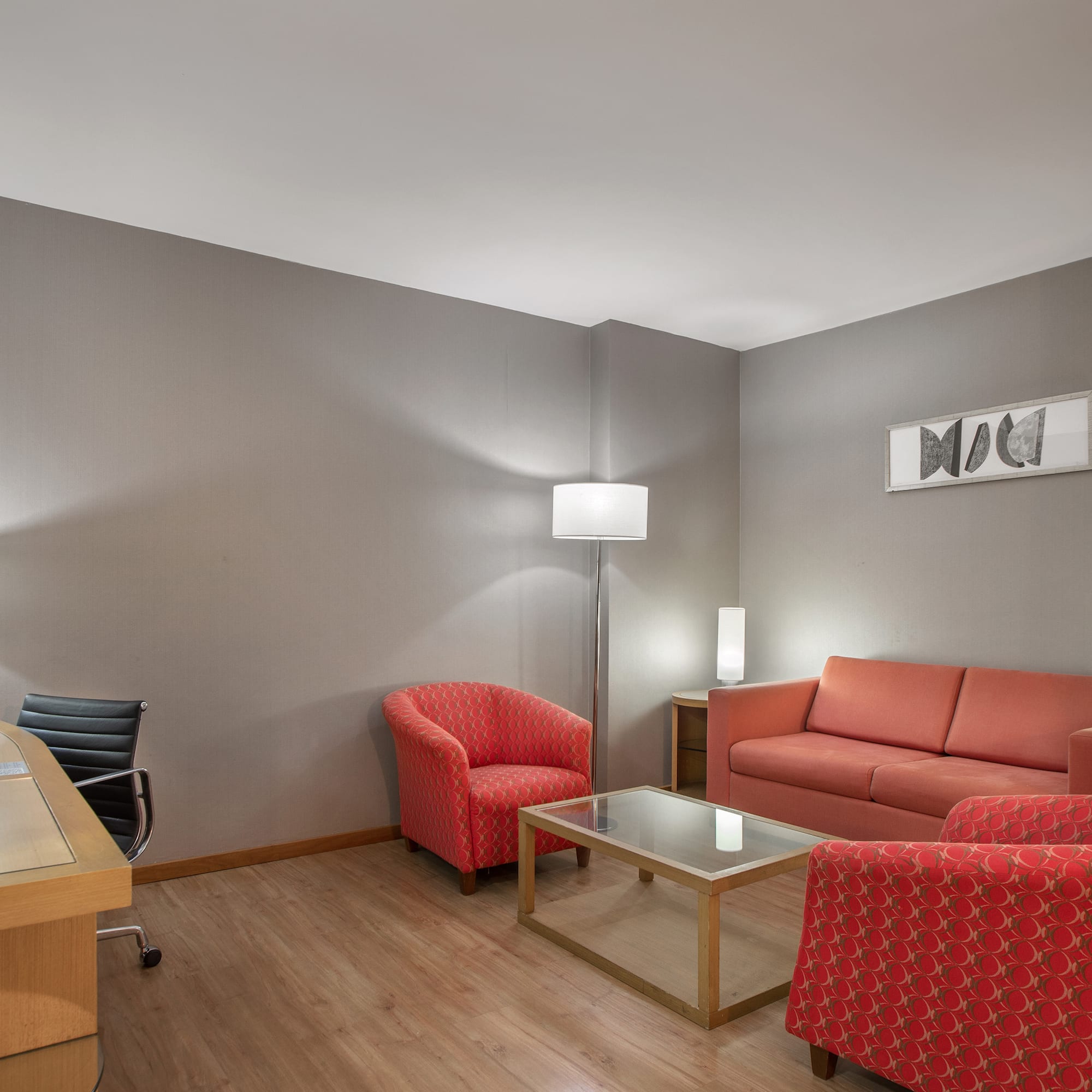 a room with a desk and couches