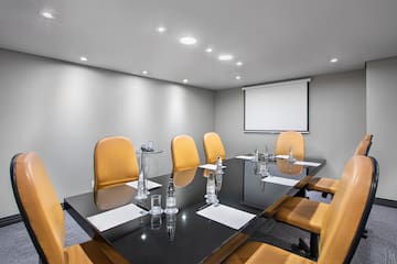 a conference room with a black table and chairs