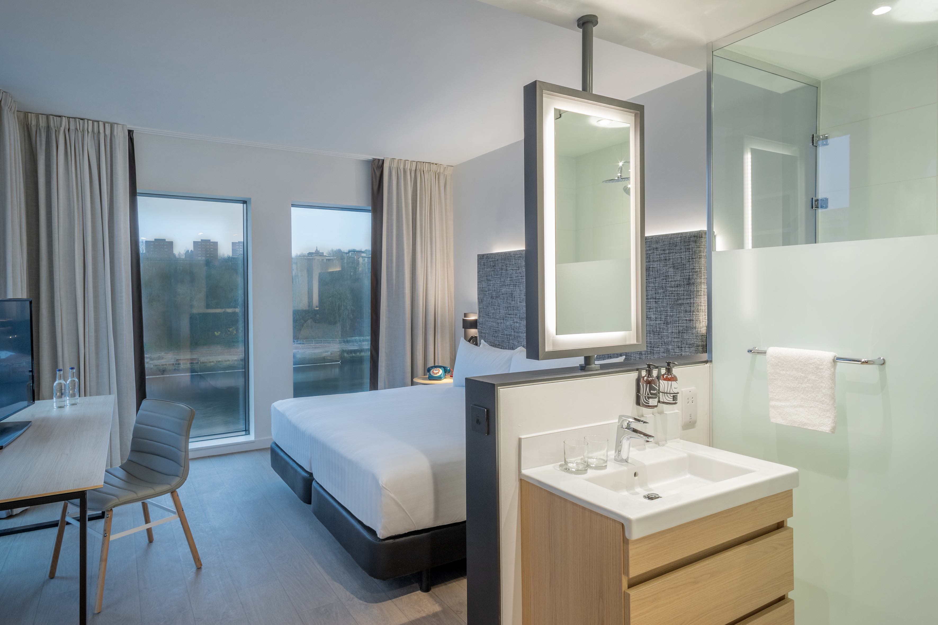 a room with a bed and sink and a chair