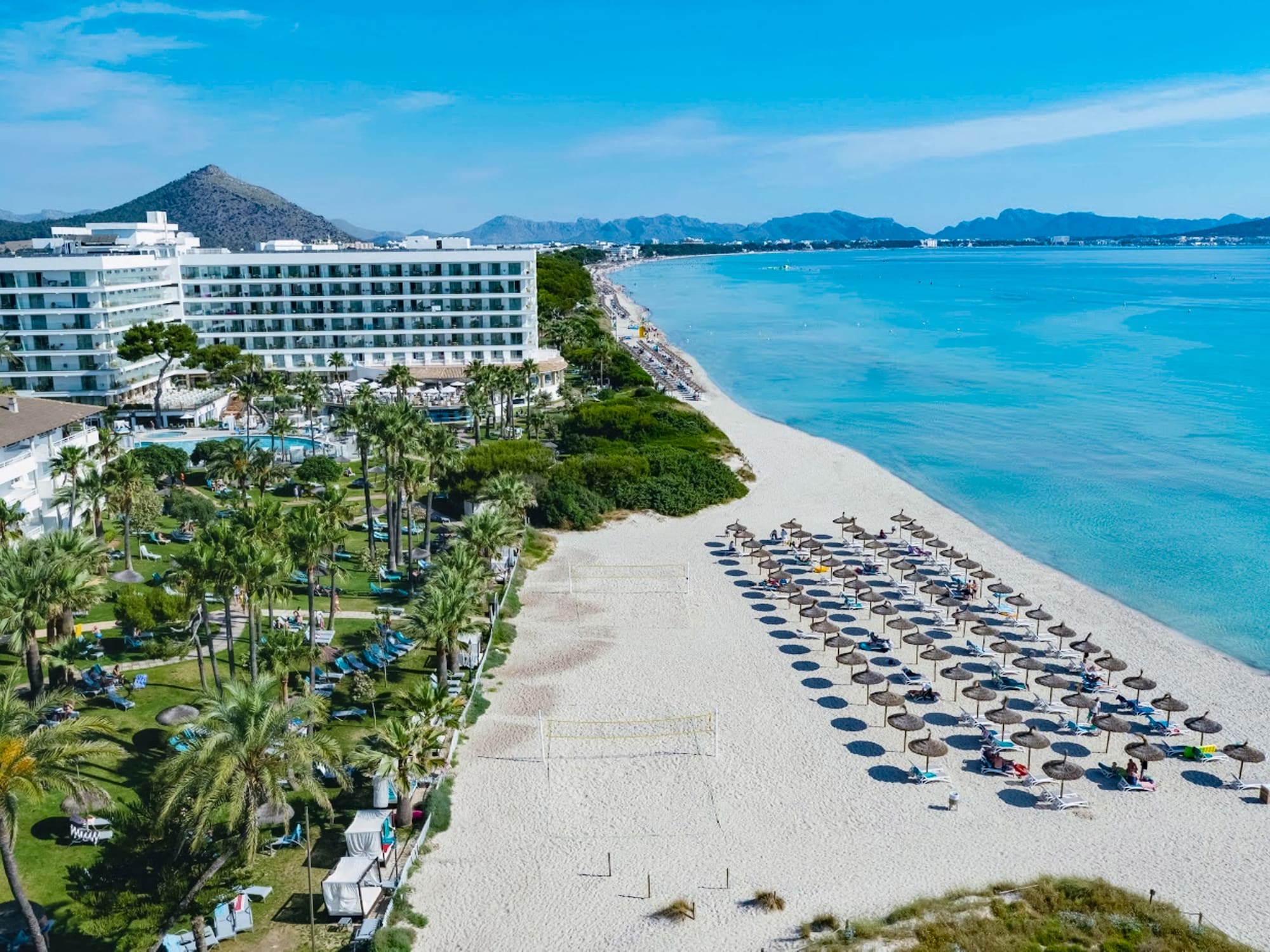a beach with umbrellas and chairs and a building on the beach