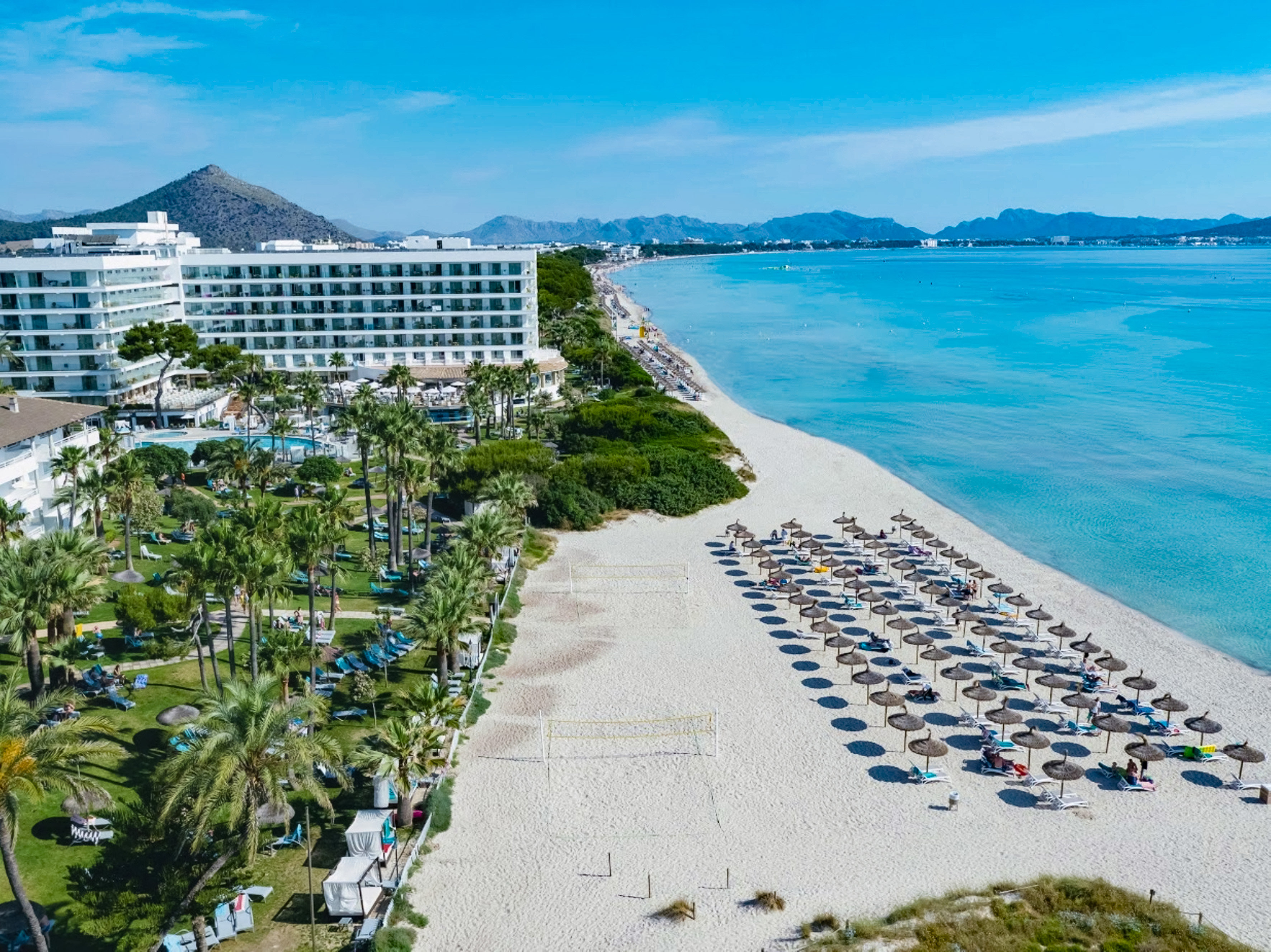 a beach with umbrellas and chairs and a building on the beach