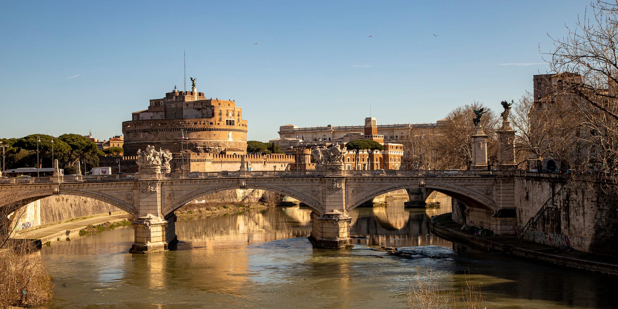 a bridge over a river with a castle in the background
