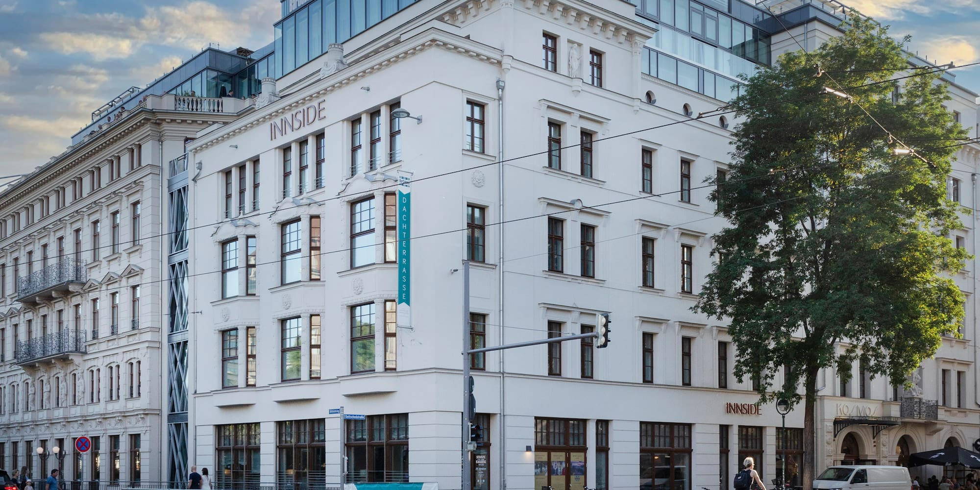 a white building with a tree and a street