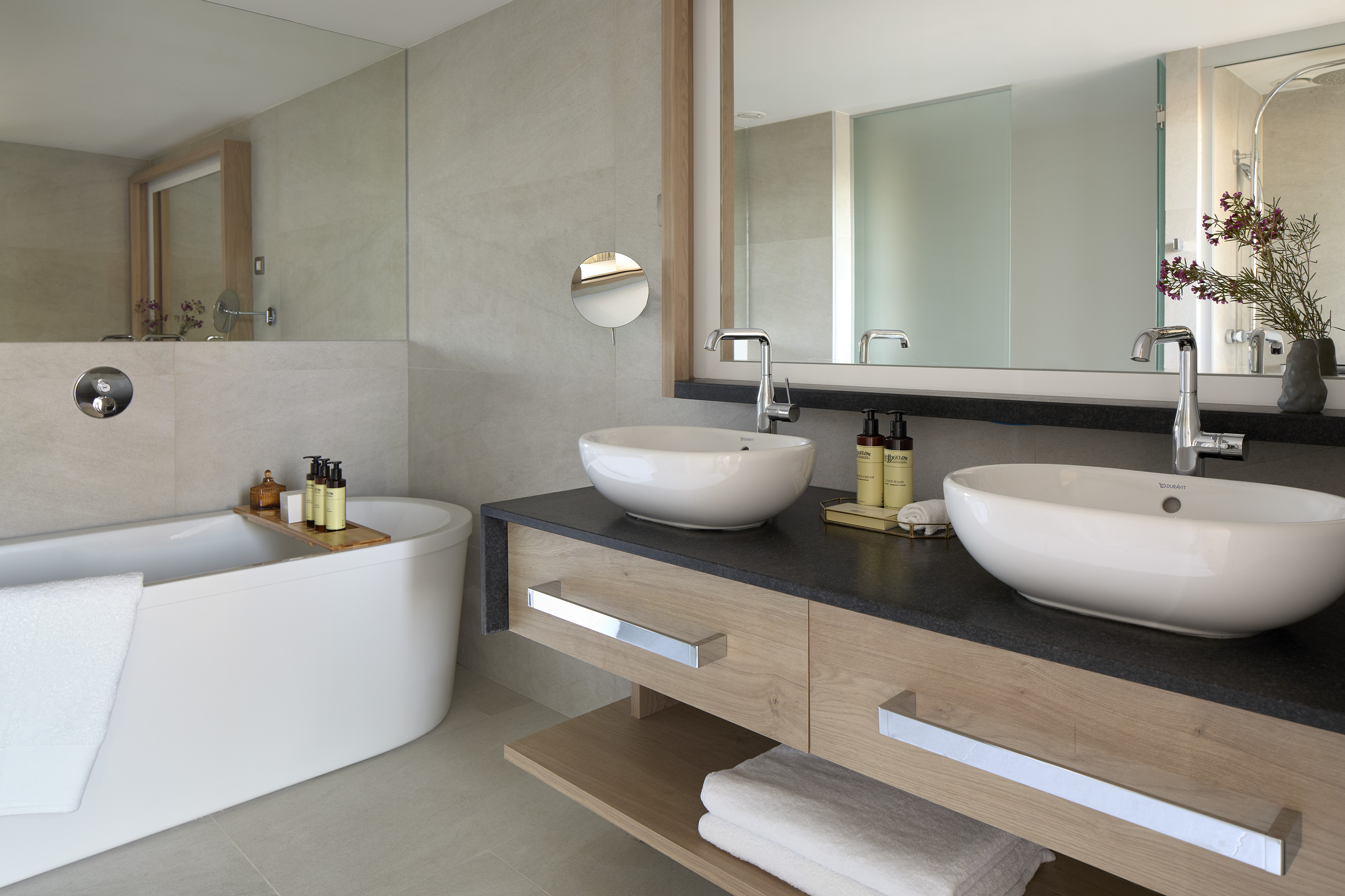 Modern luxury bathroom with freestanding tub, double vanity, and vessel sinks.