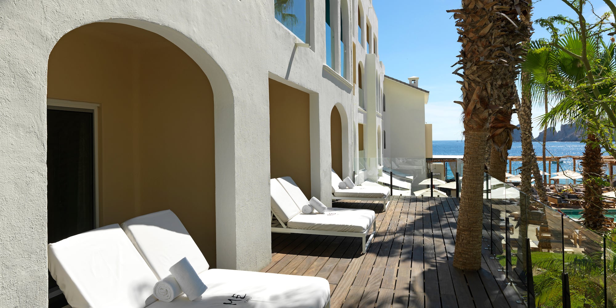 a deck with lounge chairs and palm trees