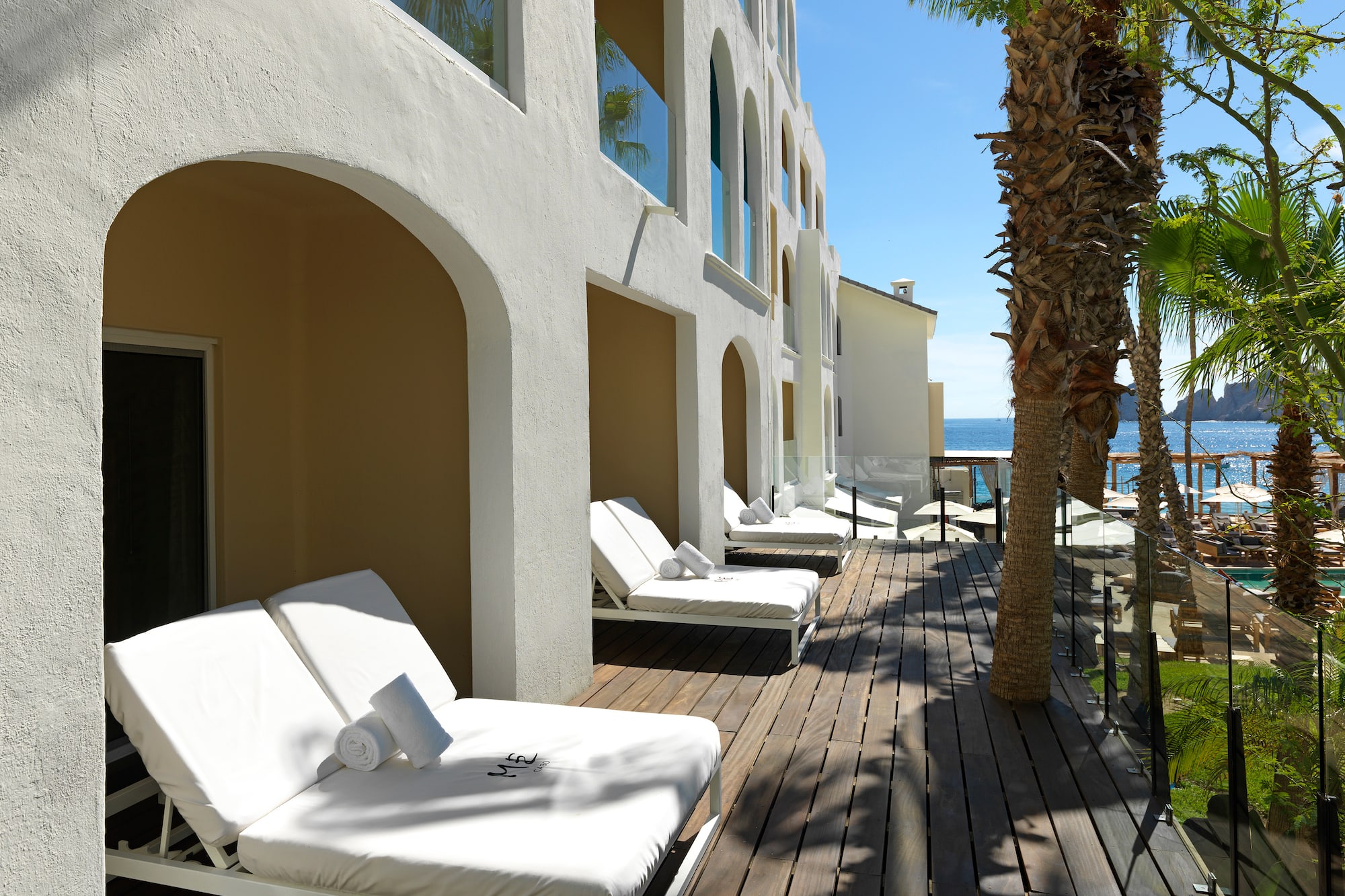 a deck with lounge chairs and palm trees