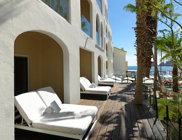a deck with lounge chairs and palm trees