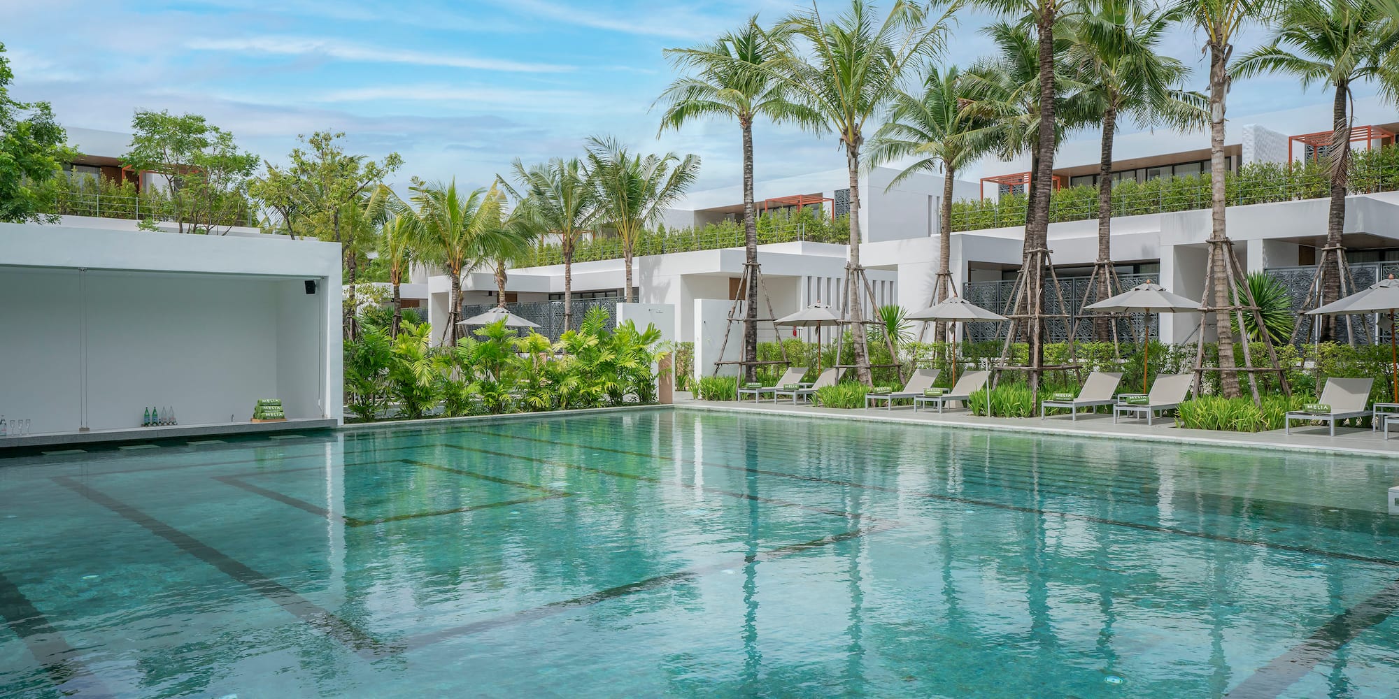 a swimming pool with palm trees and a building