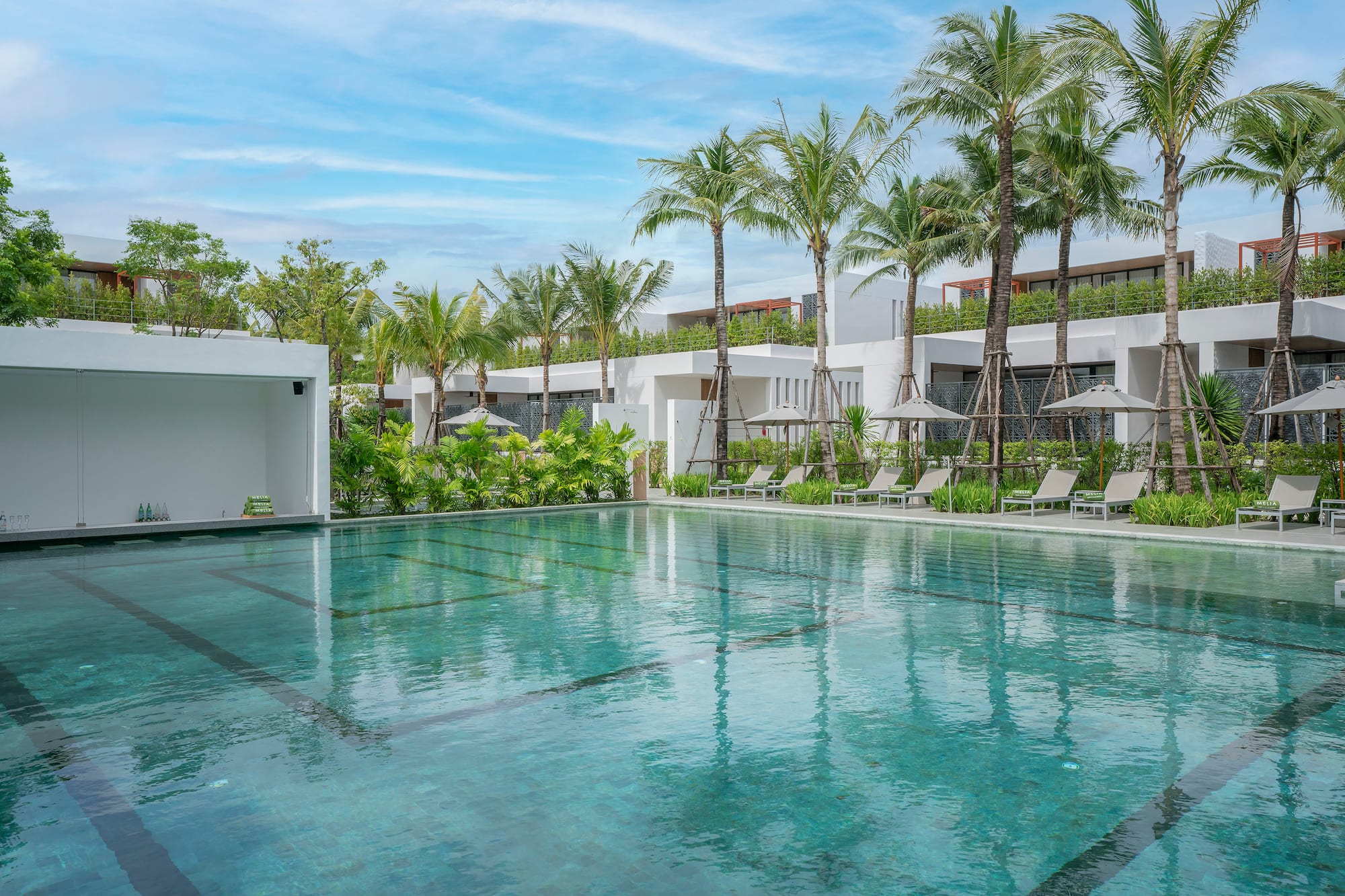 a swimming pool with palm trees and a building