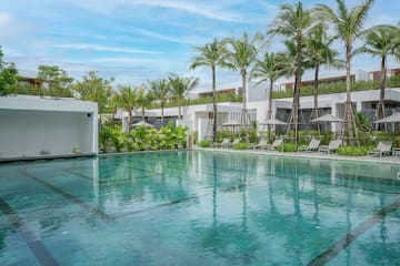 a swimming pool with palm trees and a building