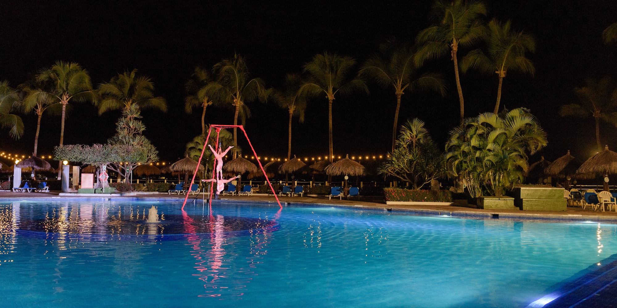 a person on a swing in a pool at night