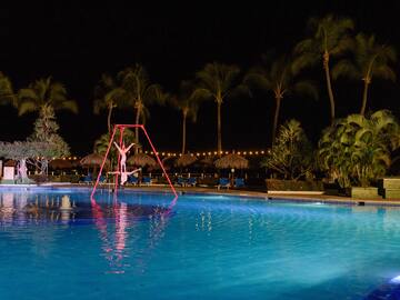 a person on a swing in a pool at night