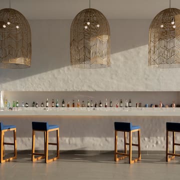 a bar with blue chairs and a row of bottles
