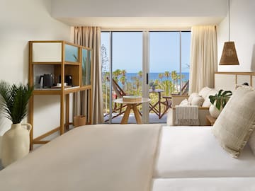 a bedroom with a view of the ocean and a balcony
