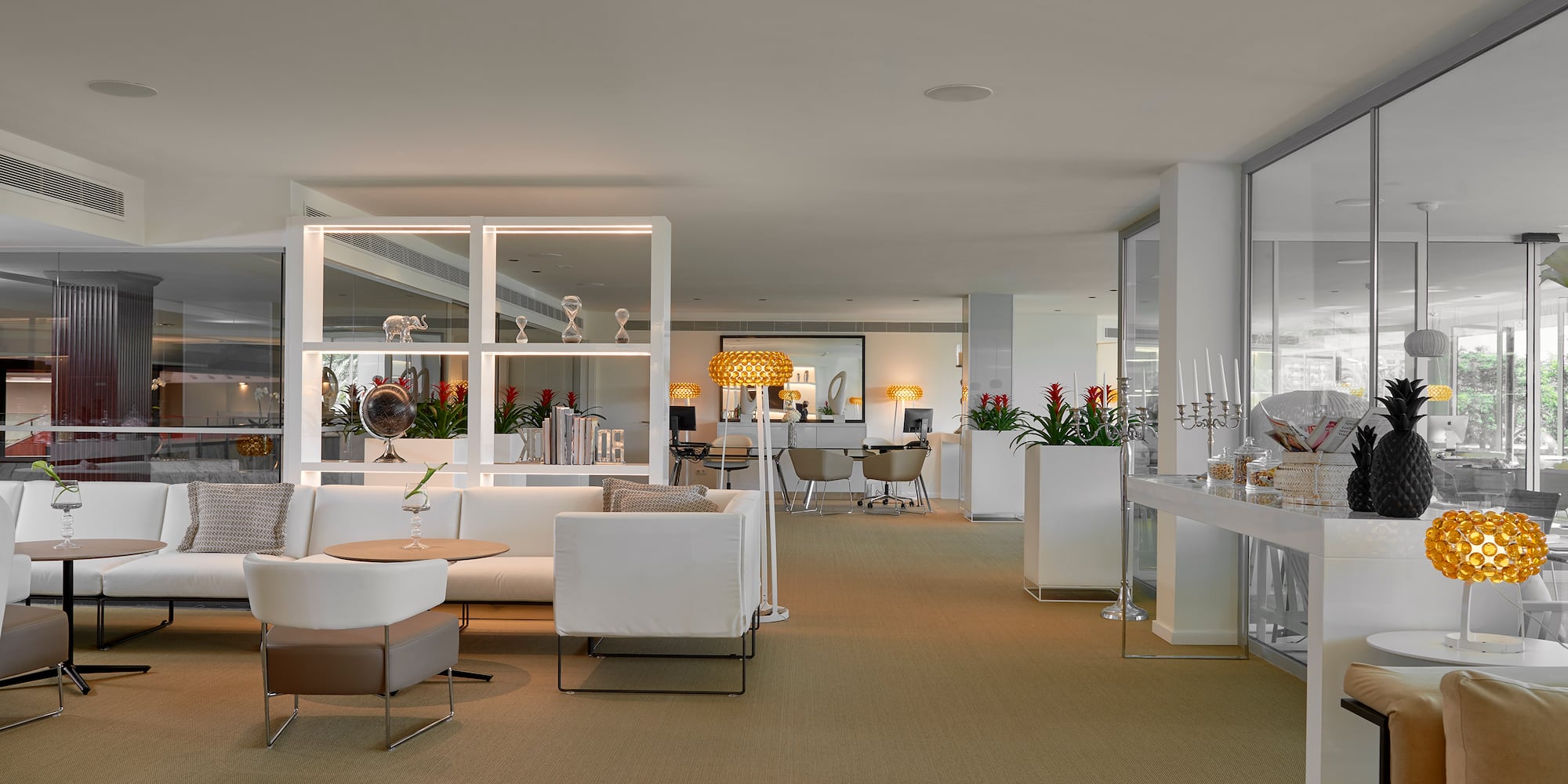 a room with white furniture and a glass wall