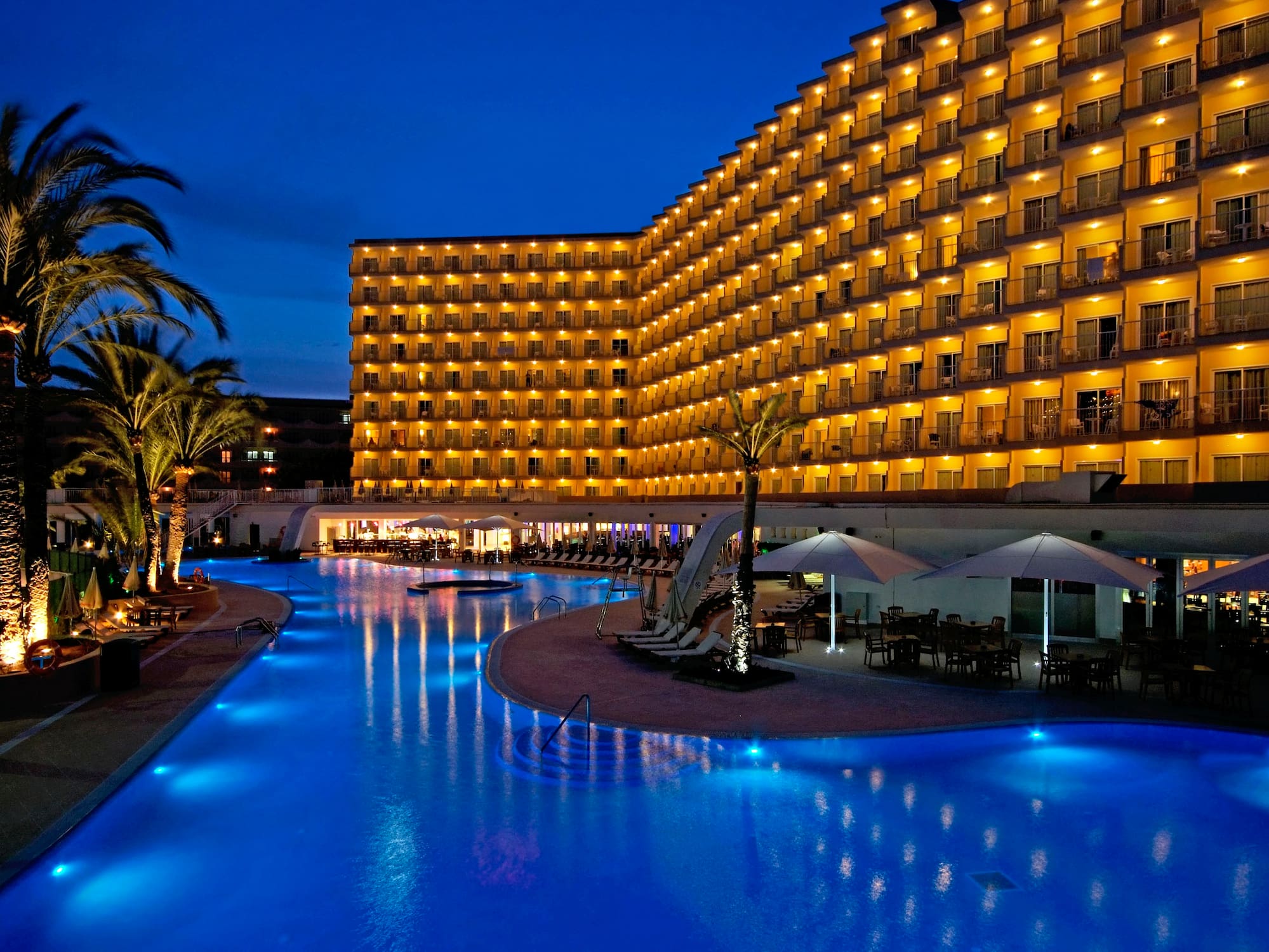a hotel with a pool and palm trees