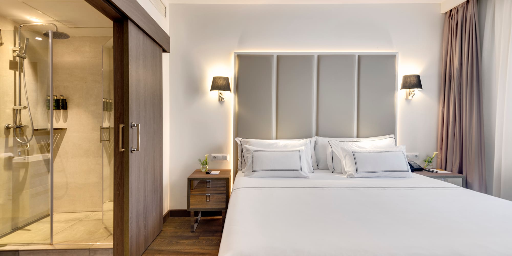 a bed with white sheets and a glass door