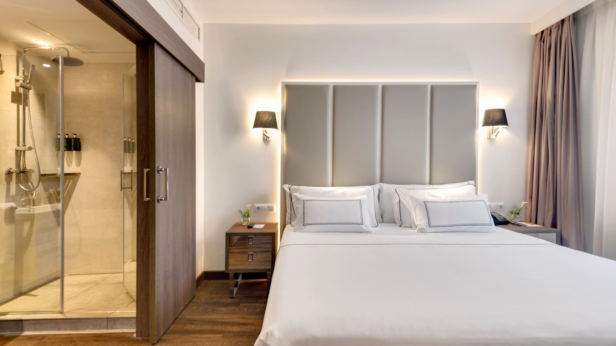 a bed with white sheets and a glass door