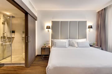 a bed with white sheets and a glass door