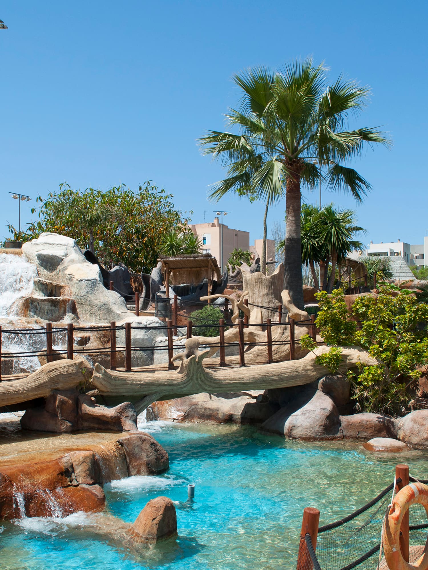 a water park with a waterfall and palm trees