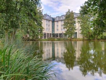 a building with trees around it and a pond