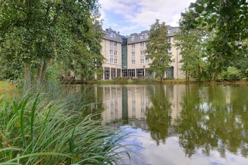 a building with trees around it and a pond