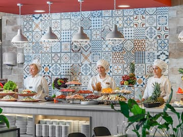 a group of people in chef's uniforms standing behind a counter