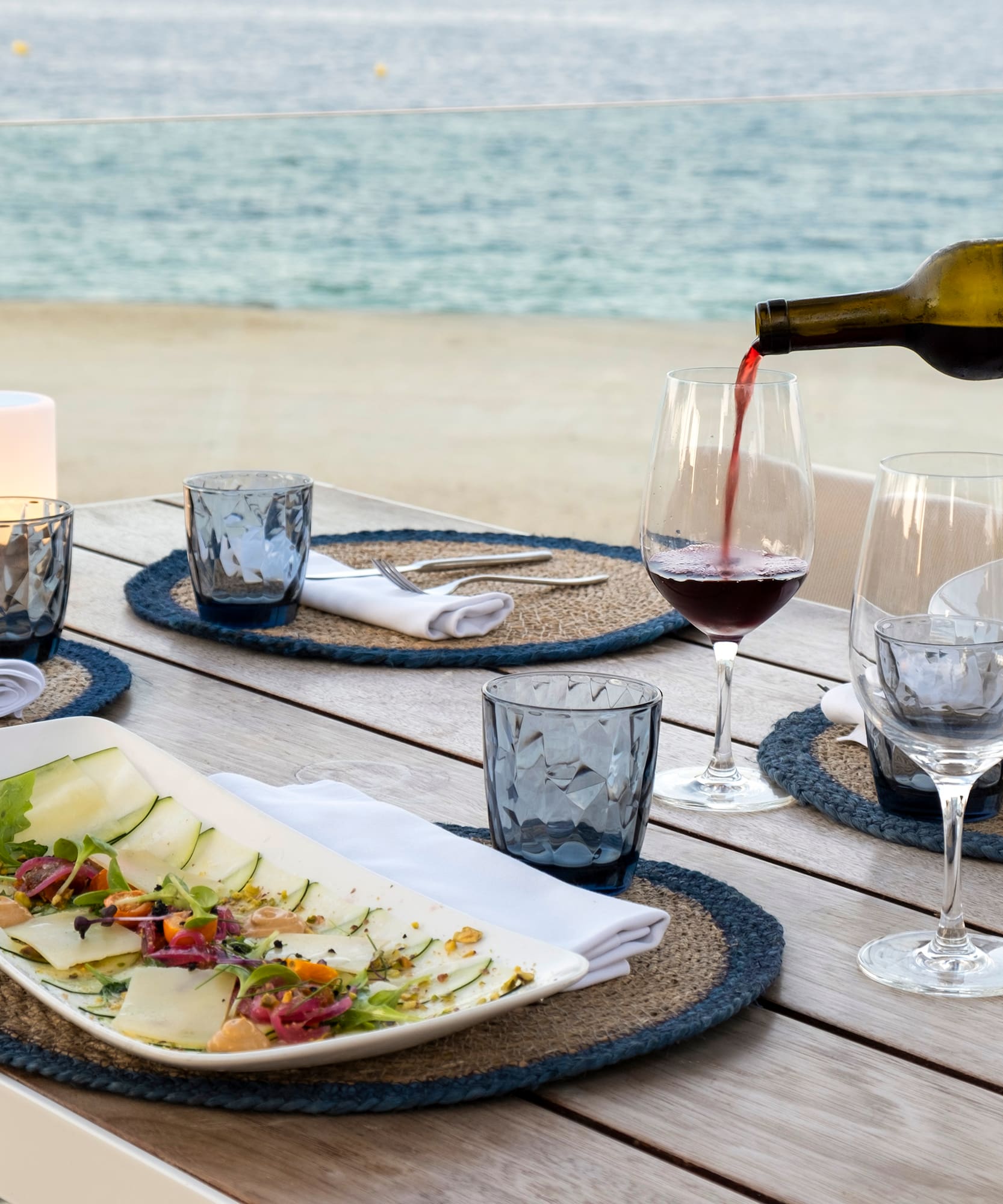 a wine being poured into a glass on a table