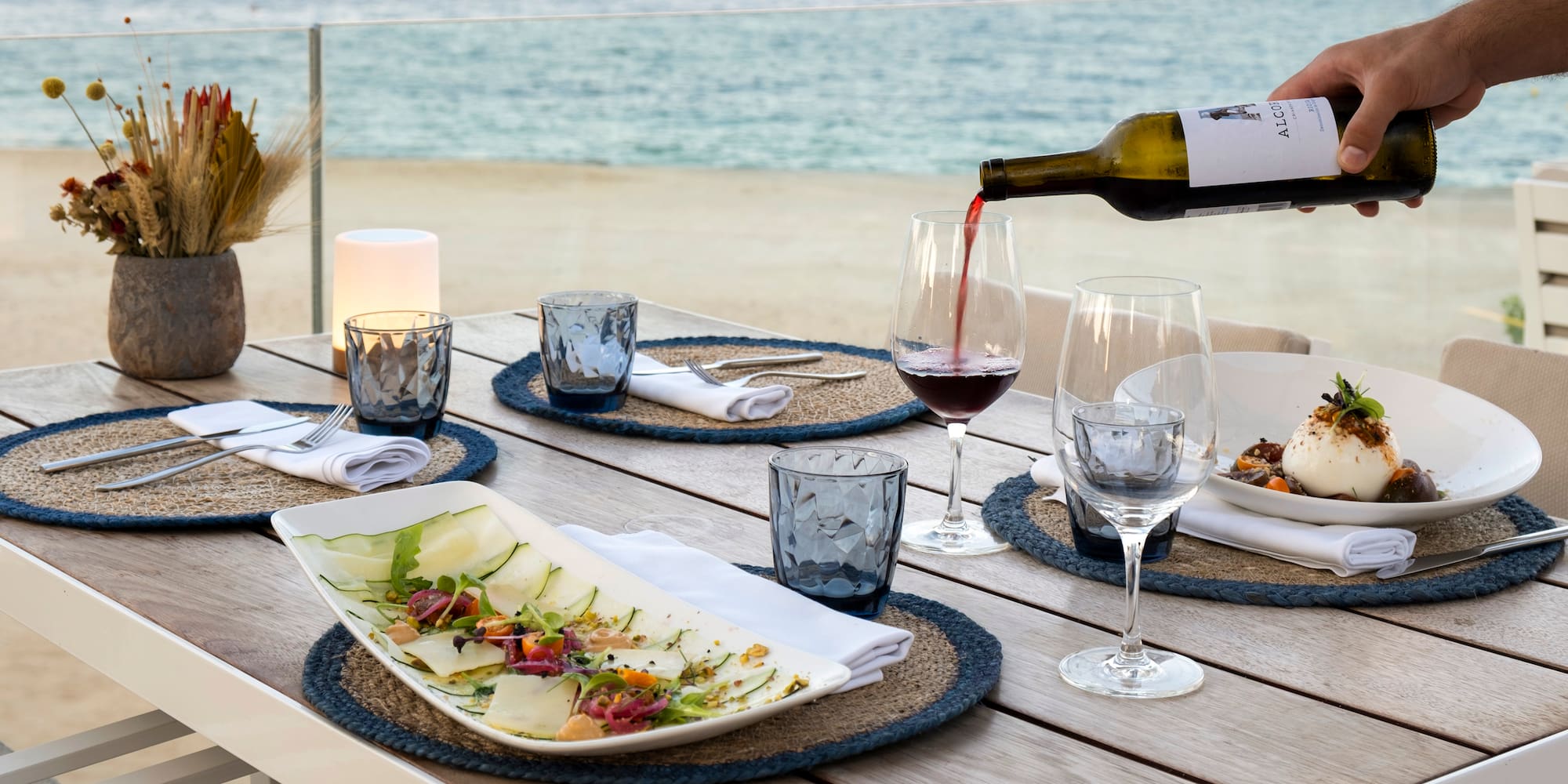 a wine being poured into a glass on a table