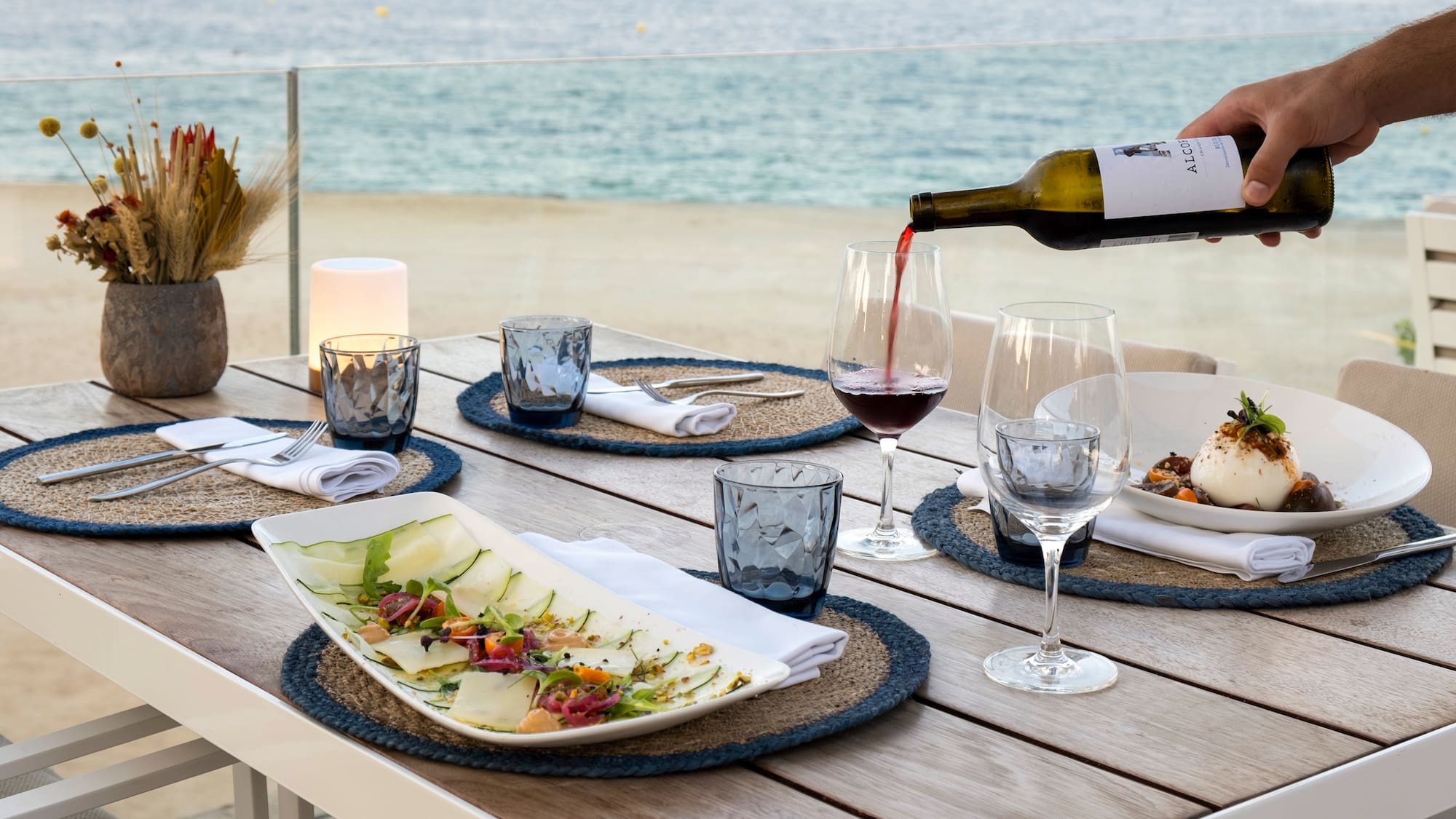 a wine being poured into a glass on a table