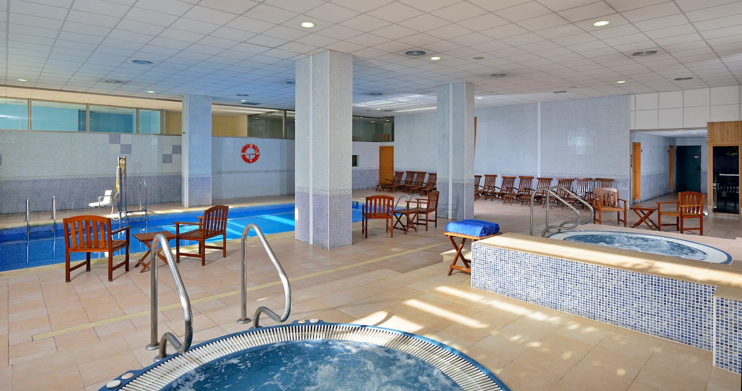 a swimming pool with chairs and a jacuzzi