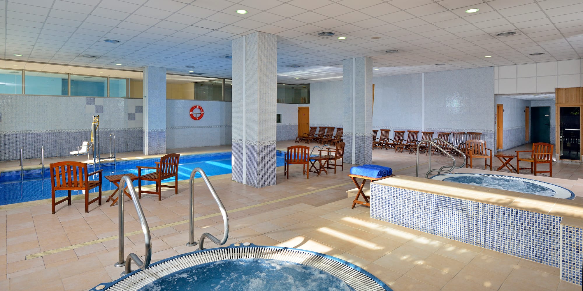 a swimming pool with chairs and a jacuzzi