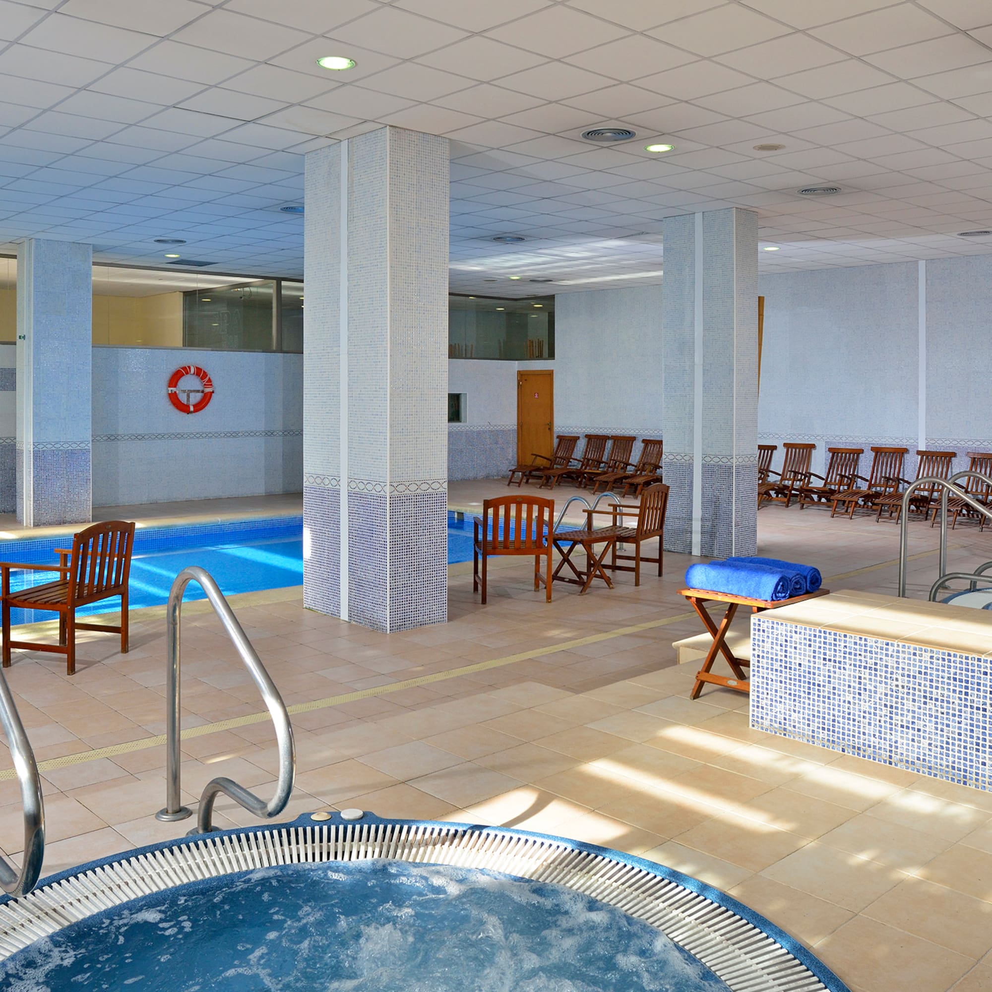 a swimming pool with chairs and a jacuzzi