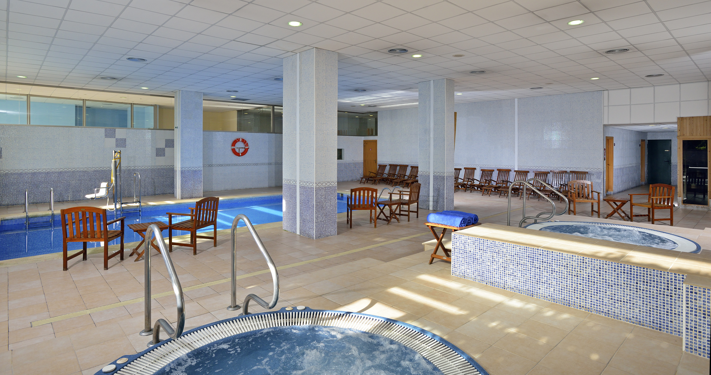 a swimming pool with chairs and a jacuzzi