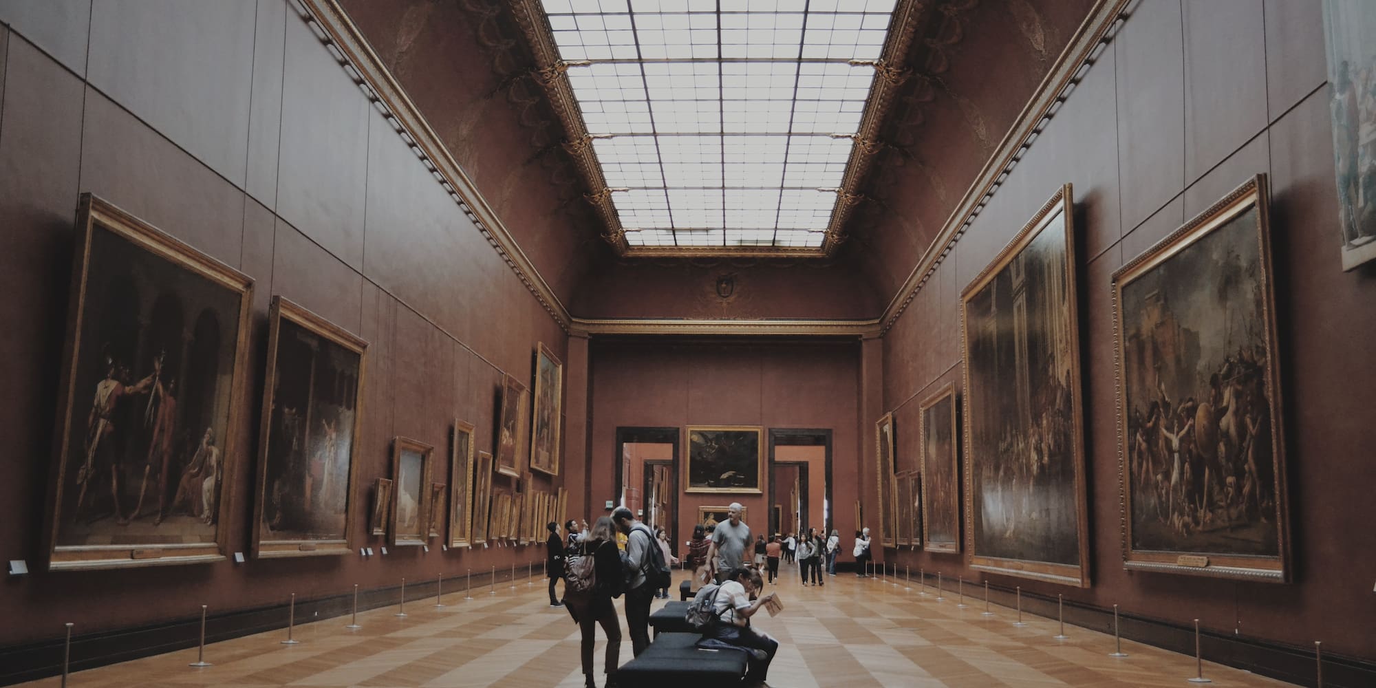 people in a museum with many paintings