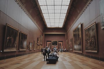 people in a museum with many paintings