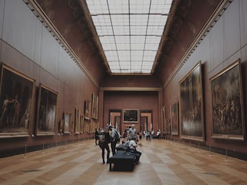 people in a museum with many paintings