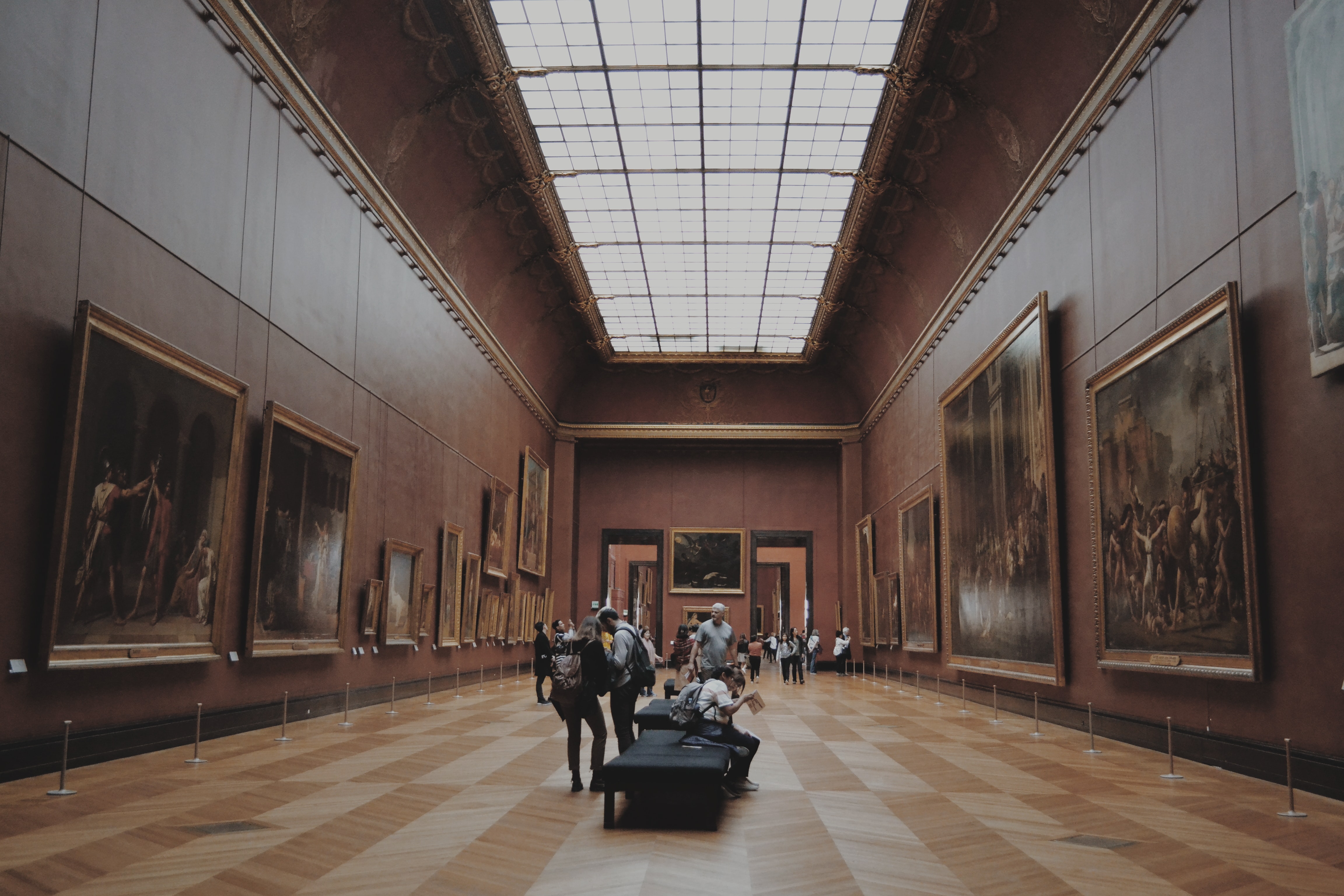 people in a museum with many paintings