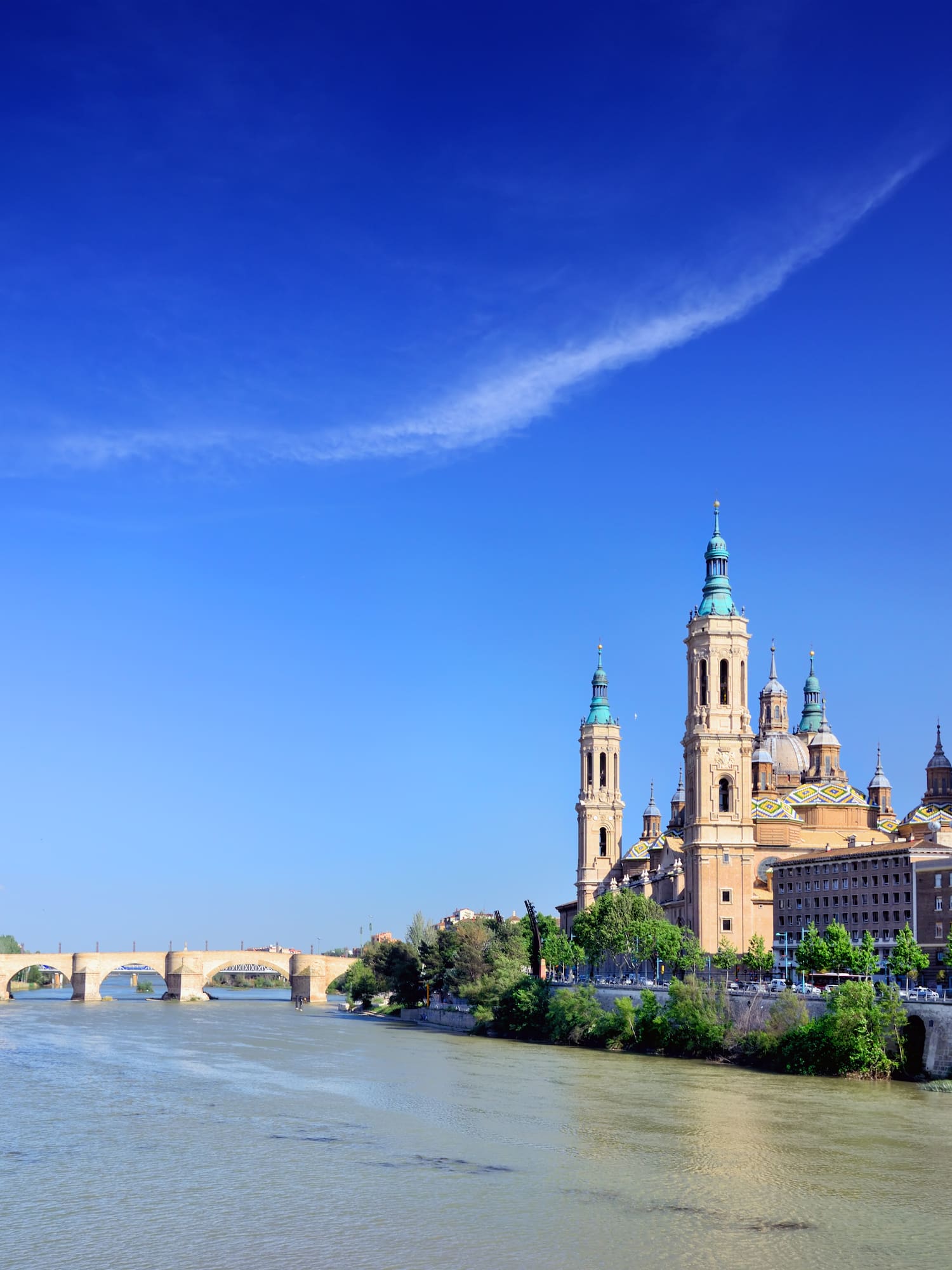 a river with a bridge and a city with towers