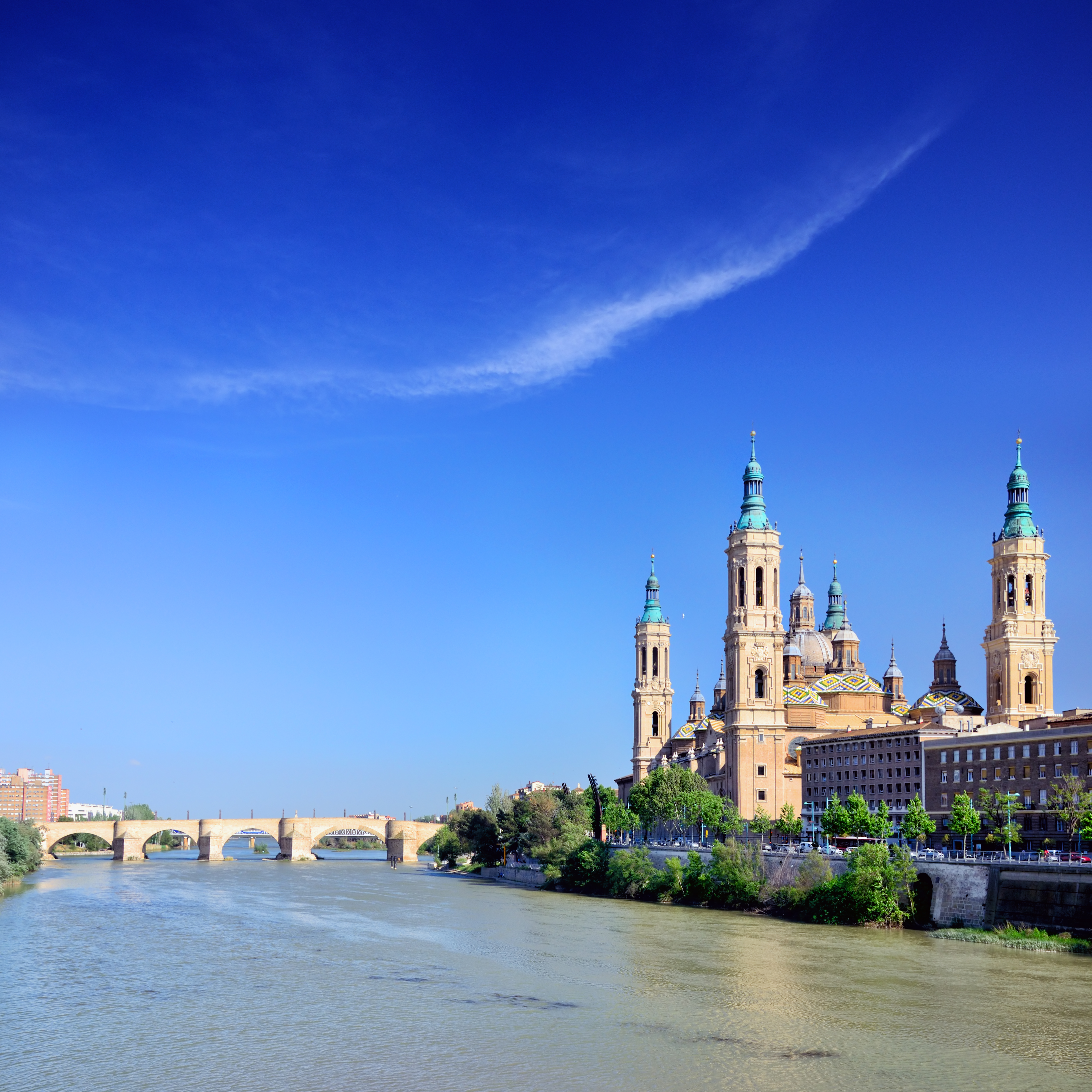 a river with a bridge and a city with towers