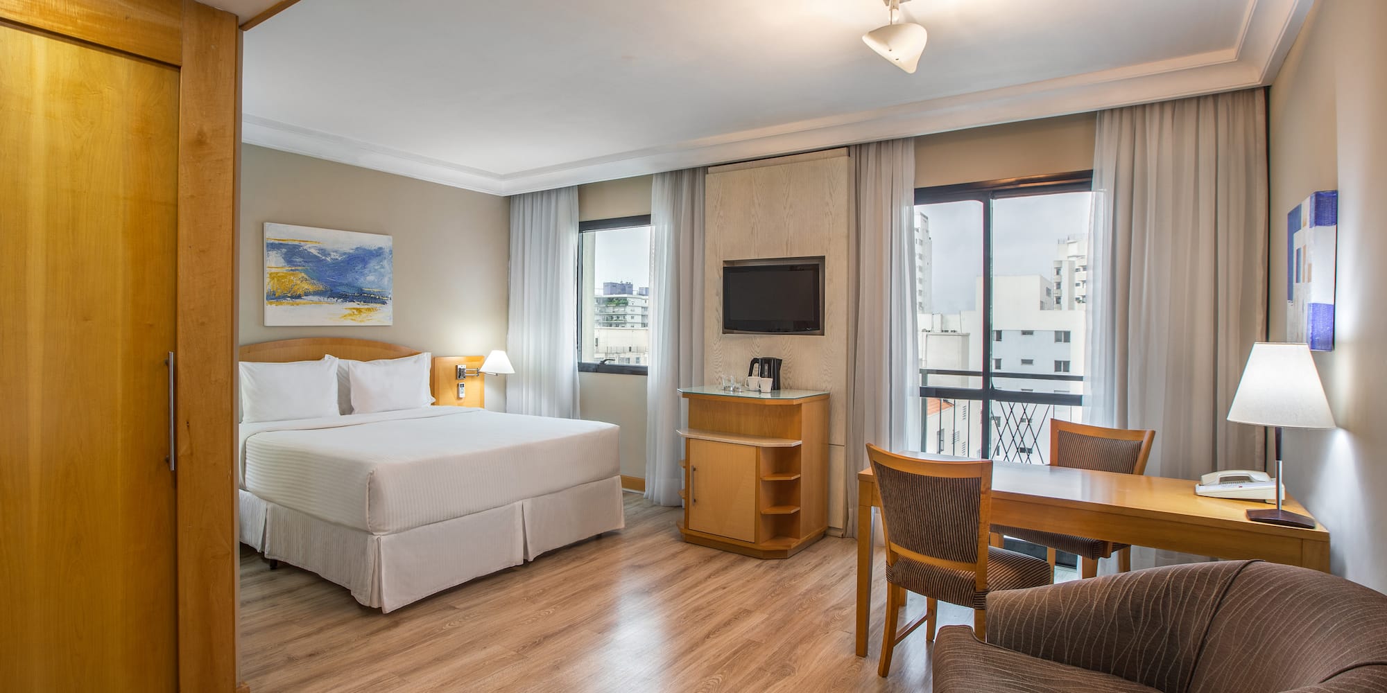 a room with a bed and a table and chairs