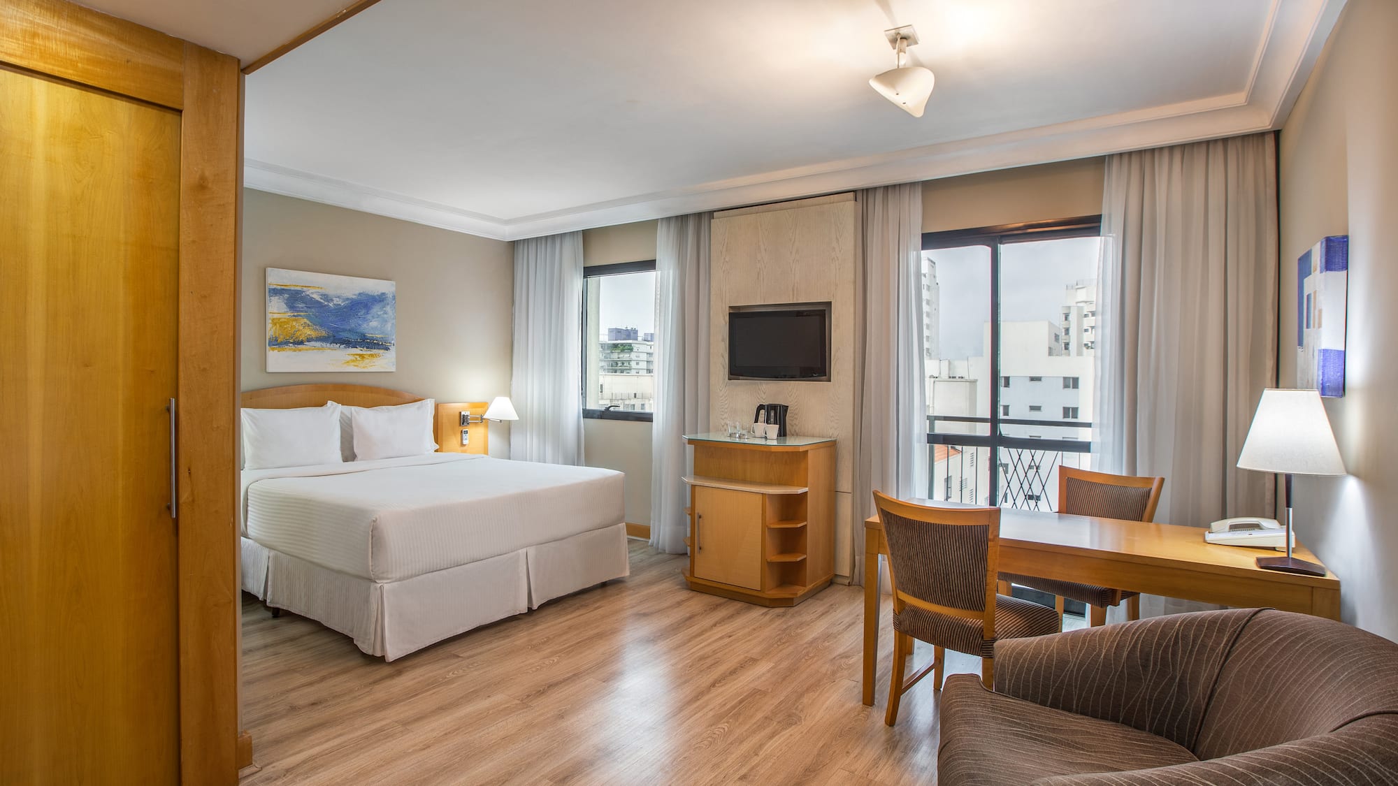 a room with a bed and a table and chairs