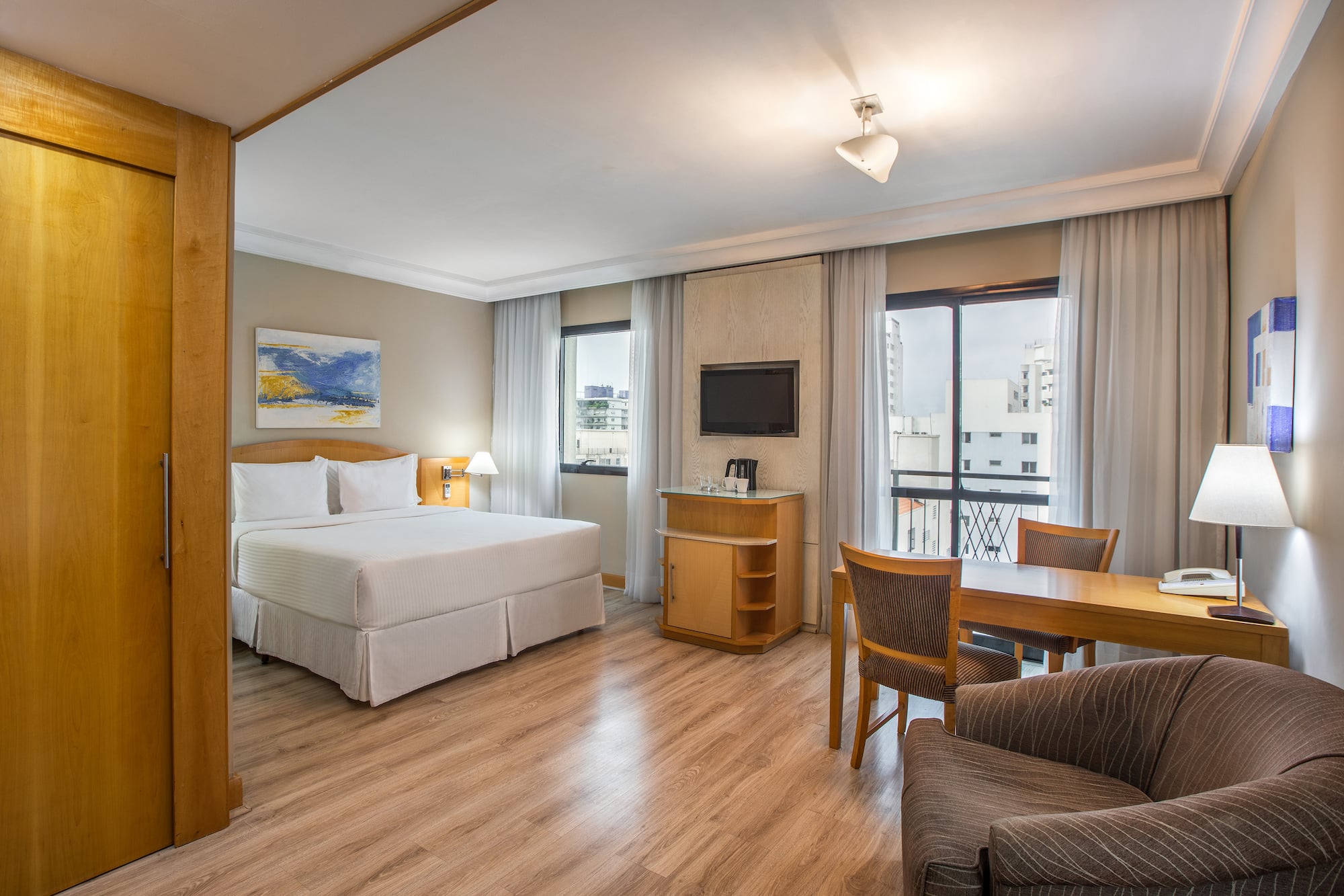 a room with a bed and a table and chairs