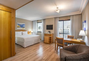 a room with a bed and a table and chairs