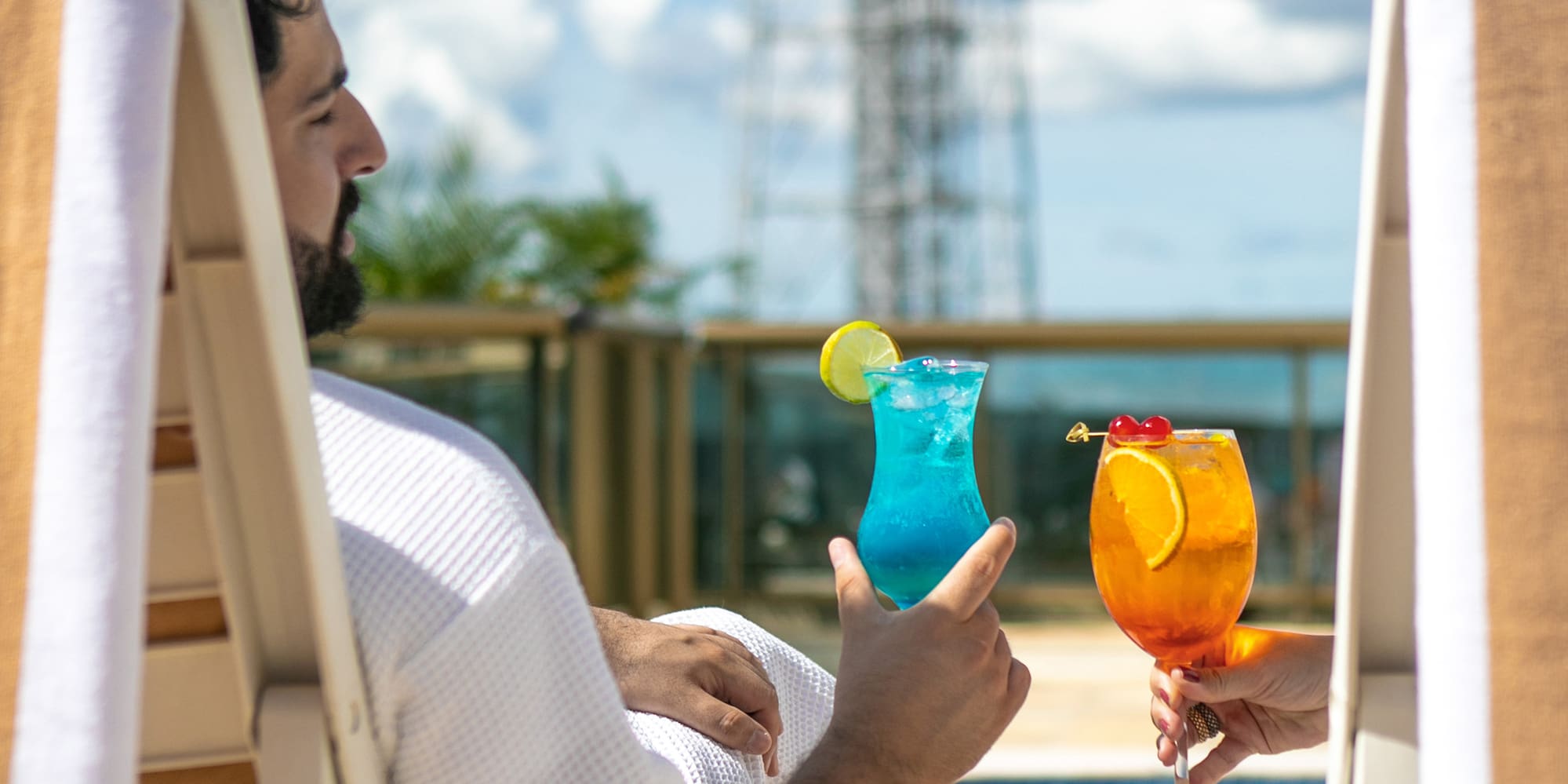 a man in a white robe holding a drink and another man in a white robe